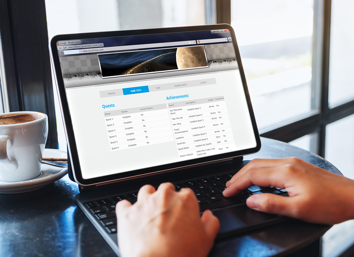 Designing Digitally - Person using a laptop with an eLearning vendor's website displayed on screen, alongside a coffee cup on a table. Designing Digitally -
