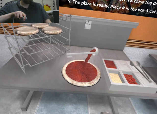 Designing Digitally - Person in a VR environment preparing pizza with virtual ingredients on a counter, including sauce, cheese, and pepperoni, with additional dough bases visible on a rack—an innovative fast food training simulation. Designing Digitally -