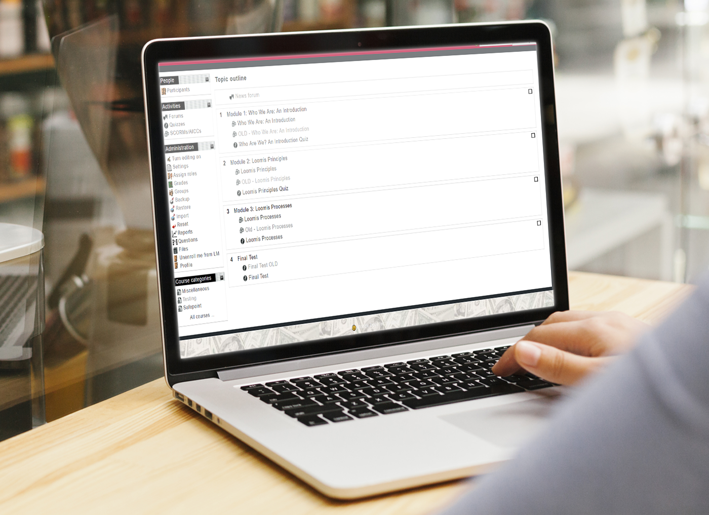 A person working on a laptop with a spreadsheet application open, analyzing data for a Custom Learning Management System vendor.