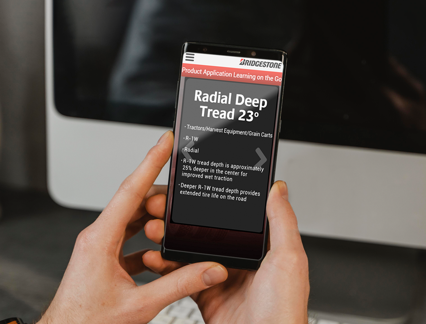 Person holding a smartphone with the Mobile Product Application Training on bridgestone radial deep tread 23° tires.