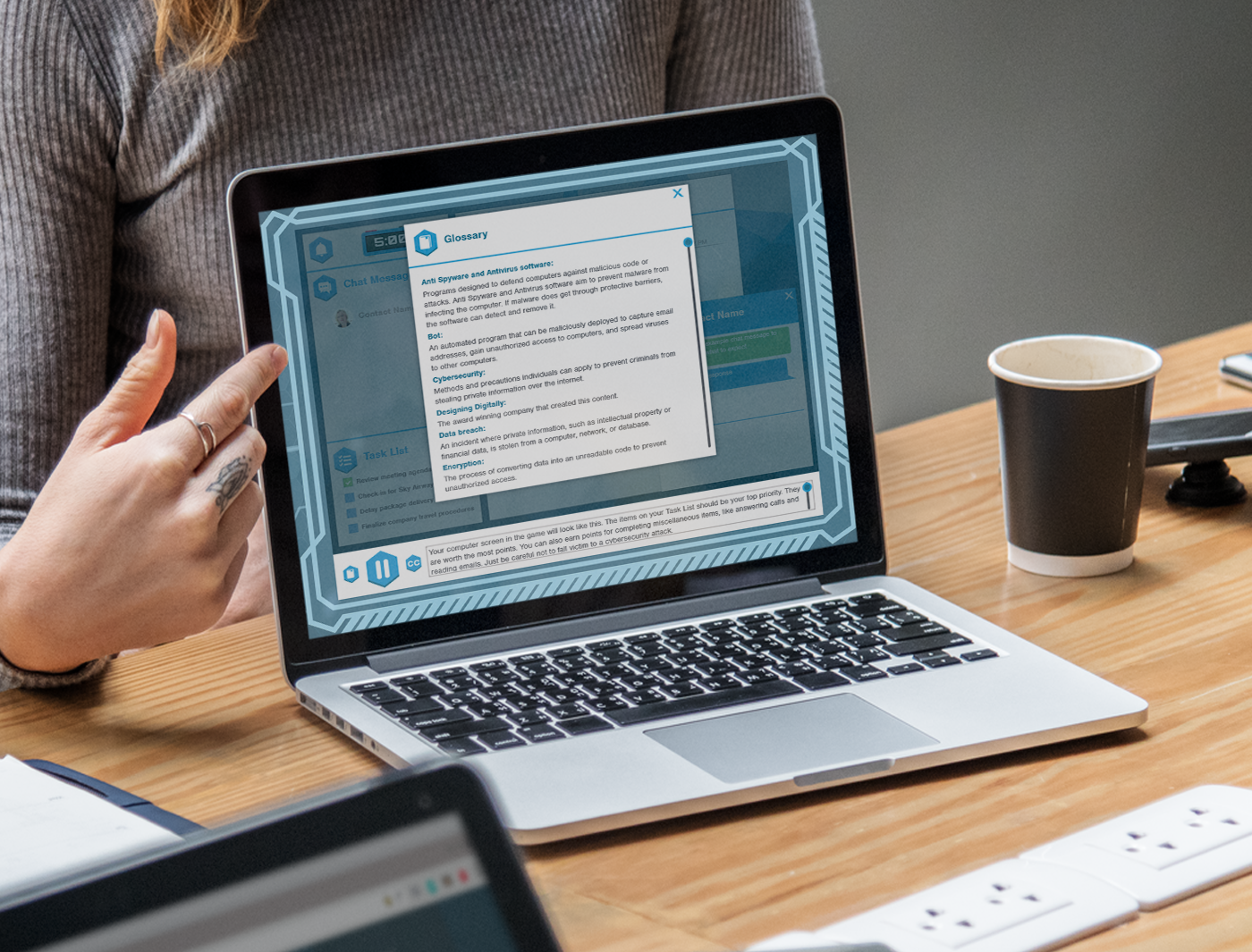 A person gestures toward a laptop screen displaying a cyber security assessment interface during a meeting.
