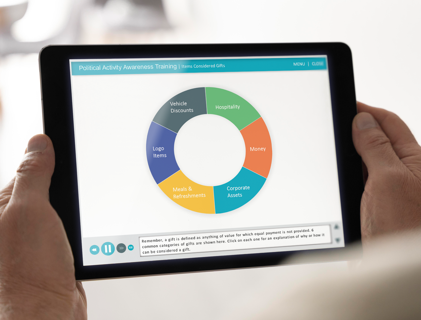 Person holding a tablet displaying a pie chart on "Political Activity and Lobbying Awareness Training - items considered gifts.