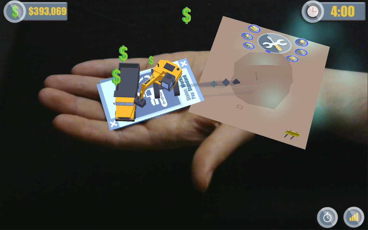 A person's hand interacting with virtual augmented reality elements, including money and construction vehicles, displayed over the hand in an Augmented Reality Training Game.