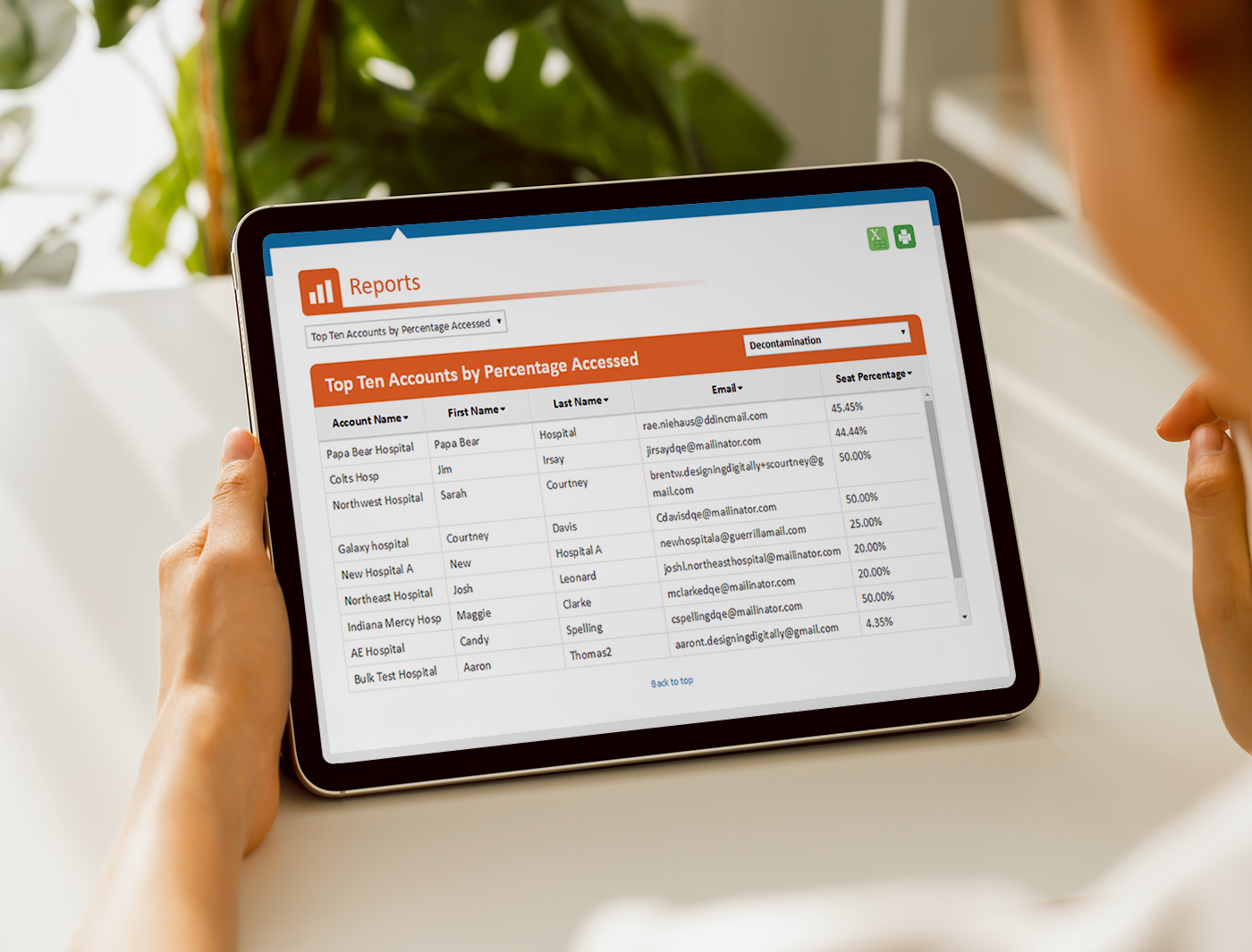 Designing Digitally - Person viewing a financial report on a tablet showing top ten accounts by percentage accessed by an Online Training Vendor. Designing Digitally -