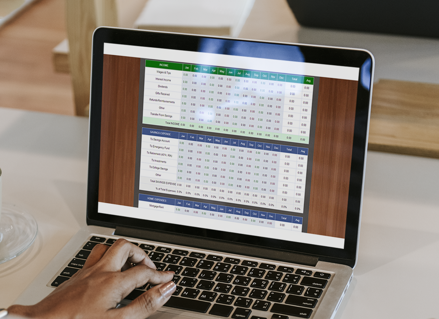 Designing Digitally - A laptop displaying an online training program, including various metrics and data on the screen, is placed on a wooden table. Hands of a person typing are visible. Designing Digitally -