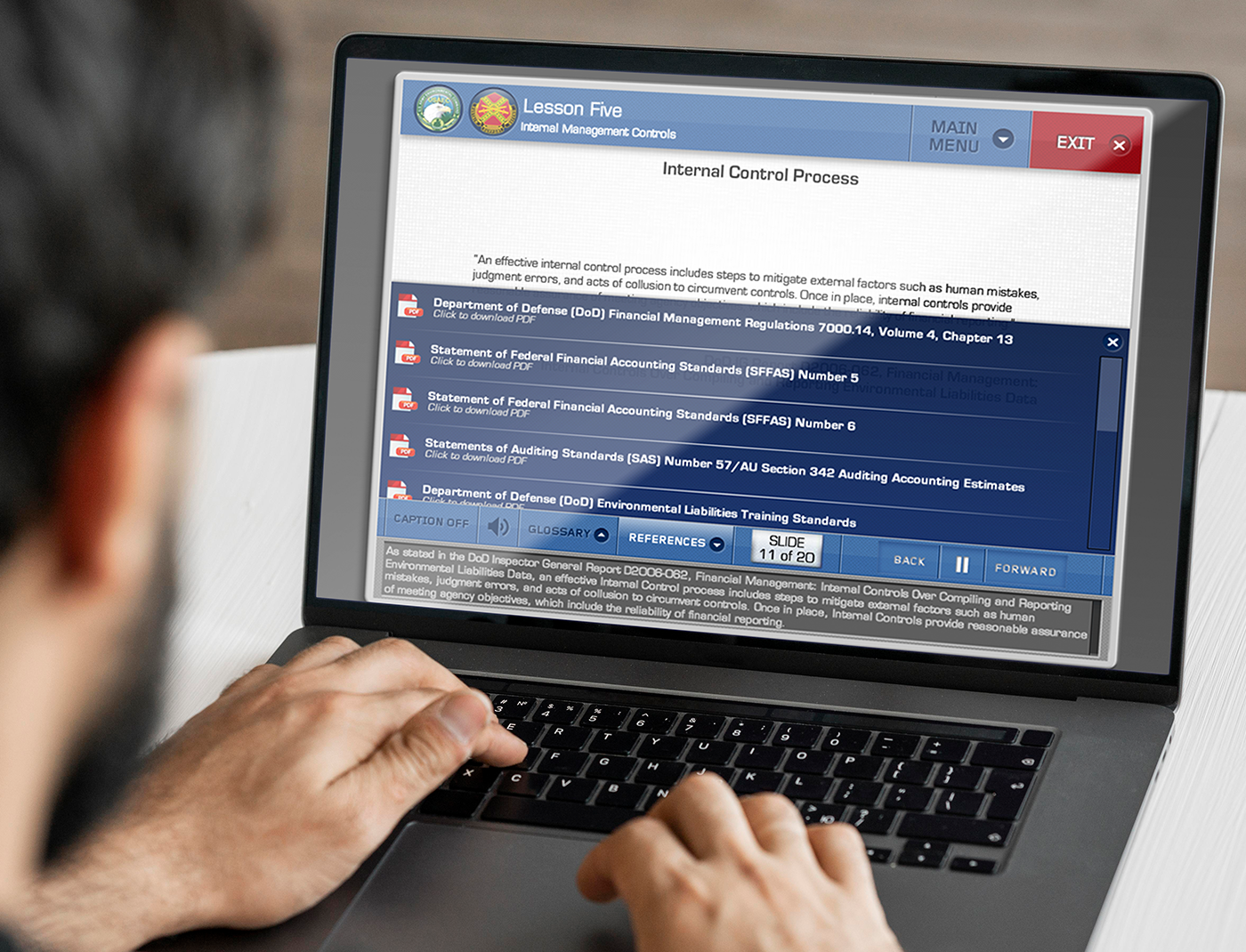 A man participating in Environmental Liability Training Online, diligently typing on a laptop screen.