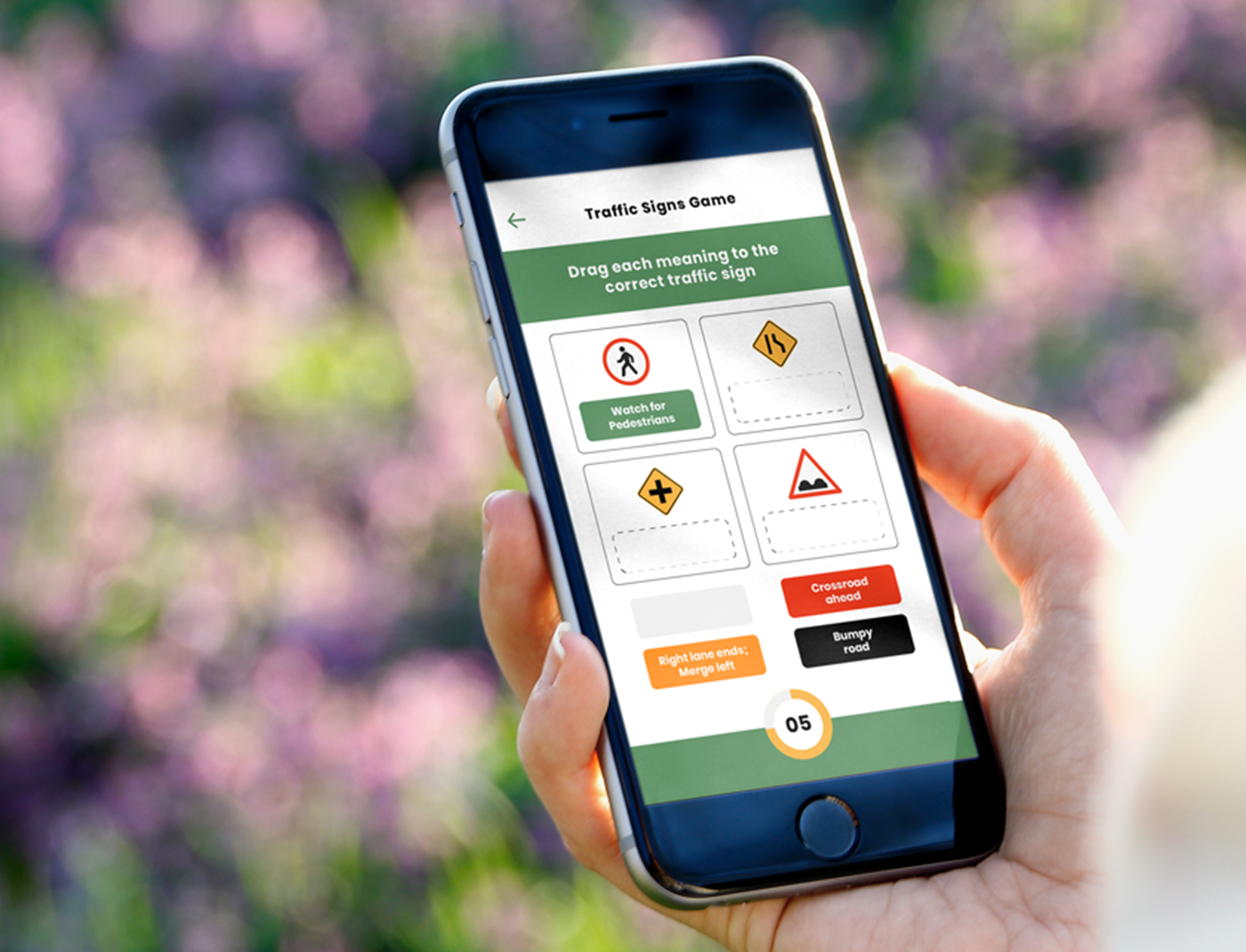 A person using a mobile application for drivers education while holding a cell phone with a traffic sign displaying on it.