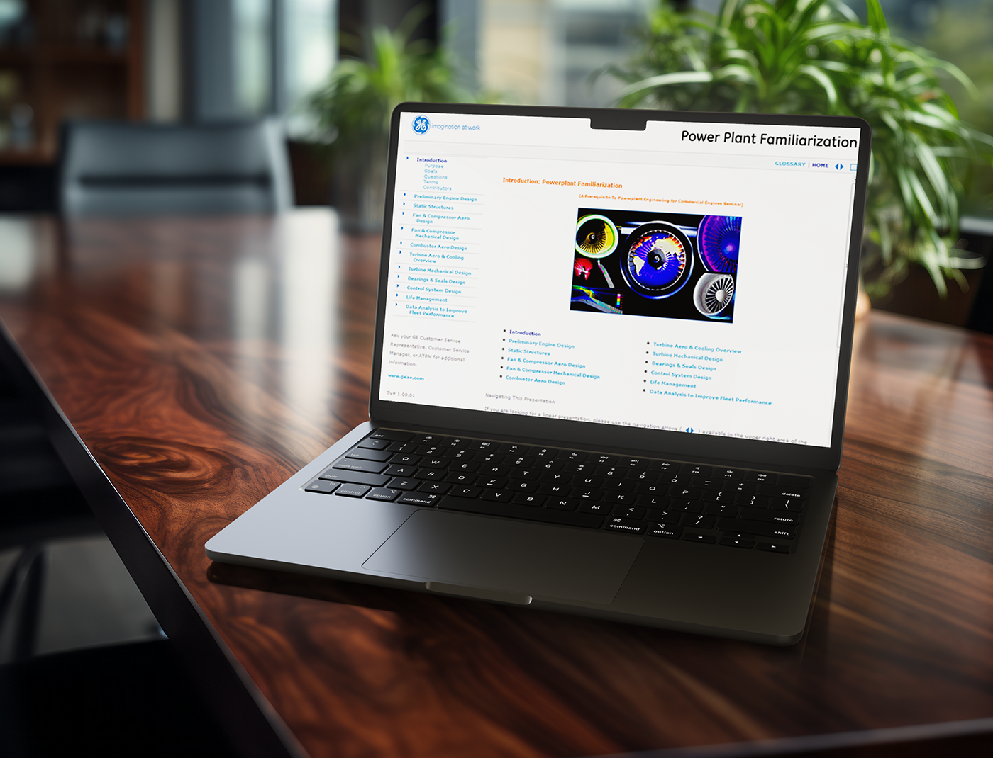 Designing Digitally - A laptop on a wooden conference table displays a webpage titled "Power Plant Familiarization" with various plant information and a colorful diagram. Power Plant Training Solutions can be seen in the blurred background, adding to the educational ambiance. Designing Digitally -