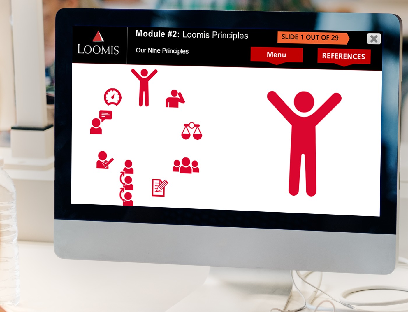 Designing Digitally - A computer monitor displaying a slide titled "Module #2: Loomis Principles" with icons representing various principles and a menu on the right, all provided by our Custom Learning Management System vendor. Designing Digitally -