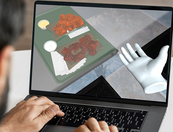 Designing Digitally - A person interacts with a computer, viewing a screen showing Wingstop's signature dishes in a 3D model and a virtual hand, perfect for food preparation training. Designing Digitally -