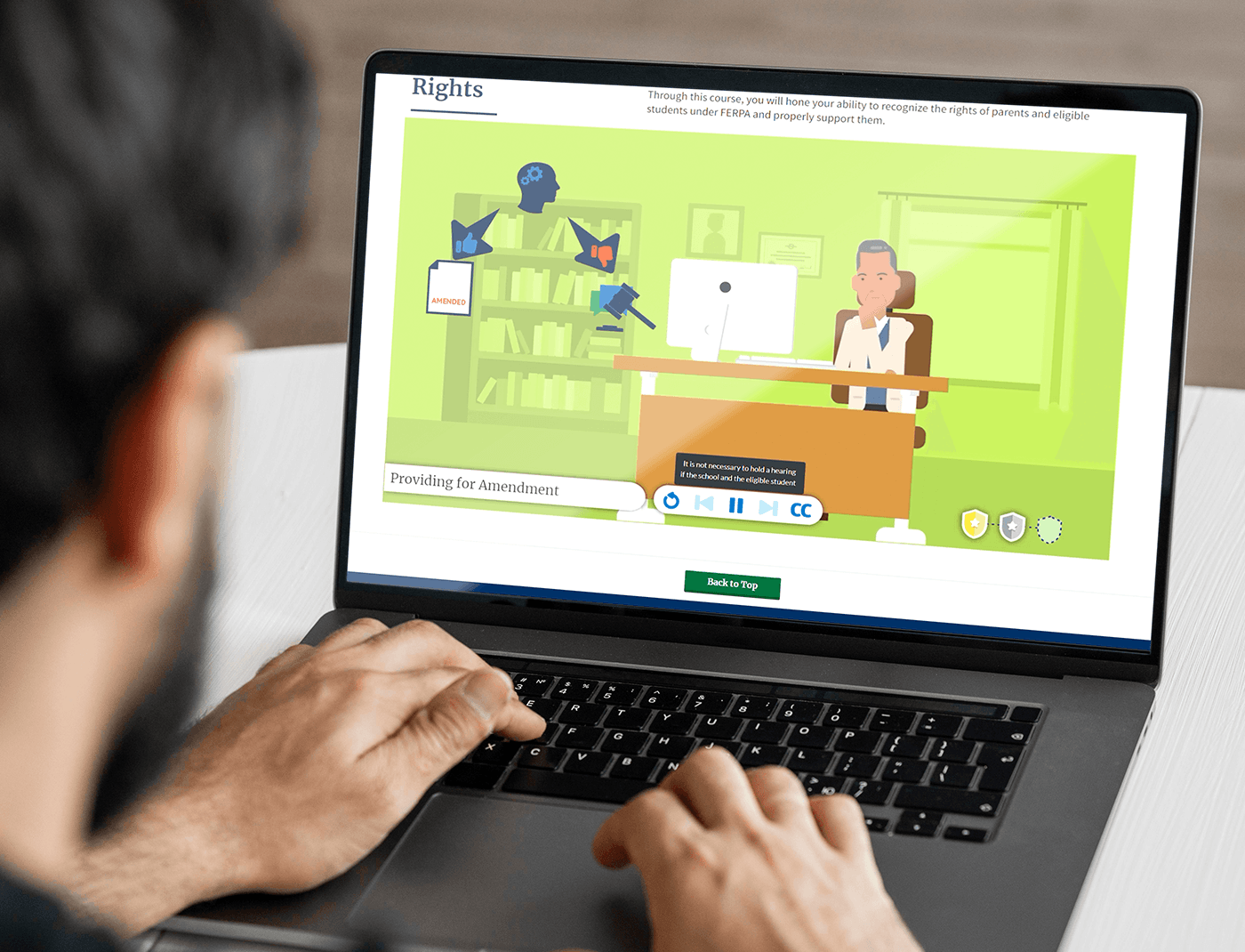 Designing Digitally - A person is using a laptop displaying an educational animation about rights, including icons for closed captions, volume control, and other settings with a "Back to Top" button at the bottom. The content seamlessly integrates occupational therapy simulations to enhance interactive learning. Designing Digitally -