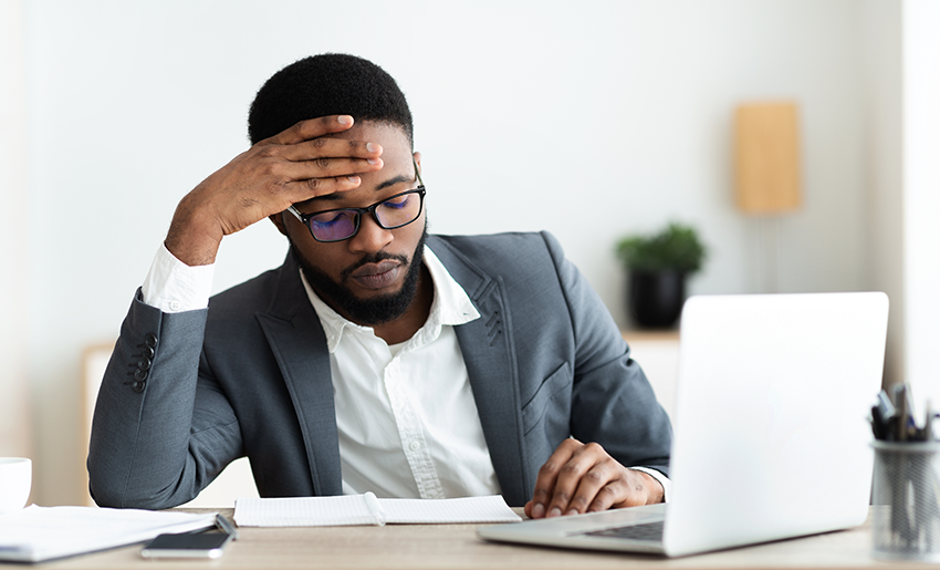 Concentrated businessman enhancing learning by analyzing information on a laptop at his desk.